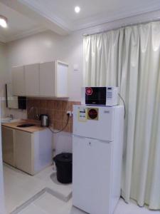 a kitchen with a microwave on top of a refrigerator at سحاب فيو in Abha