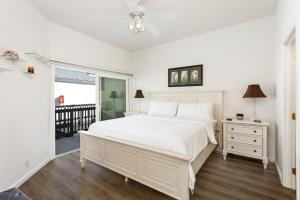 a white bedroom with a white bed and a window at 2BR Oceanfront Condo - Private Balcony - Spacious in Oceanside