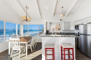 a kitchen with a table and chairs and the ocean at 2BR Oceanfront Condo - Private Balcony - Spacious in Oceanside