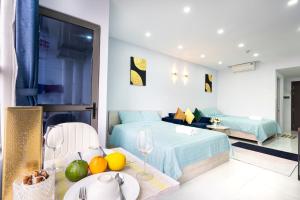 a bedroom with a bed and a table with a plate of fruit at Genius Apartment River Gate Free Pool in Ho Chi Minh City