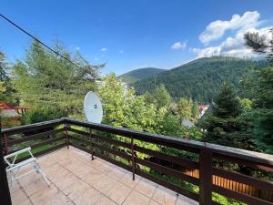 een balkon met een stoel en bergen op de achtergrond bij Chatka Janka - Malowniczy domek w Beskidach in Sopotnia Wielka