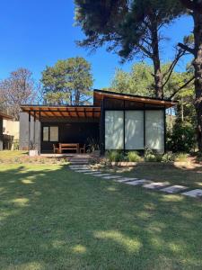 a small house with a wooden roof and windows at Sombras del Pinar in Necochea