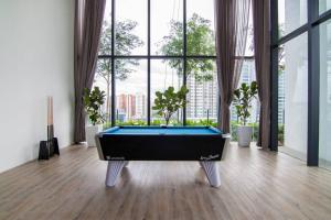 a pool table in a room with large windows at Nadi Bangsar by Plush in Kuala Lumpur