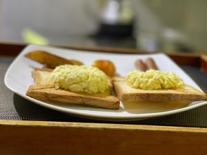 une assiette blanche avec des œufs sur du pain grillé sur une table dans l'établissement The Mastodon Valley Safari Resort, à Uda Walawe