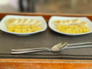 ウダワラウェにあるThe Mastodon Valley Safari Resortの食器2皿とテーブルの上のスプーン