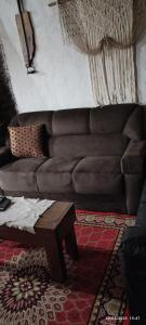 a brown leather couch in a living room with a table at Mi casa in Chuy