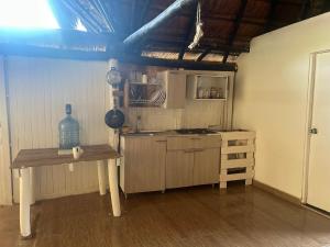 eine Küche mit einem Tisch und einem Herd im Zimmer in der Unterkunft Punta Arena EcoHostal & EcoFit in Playa Punta Arena