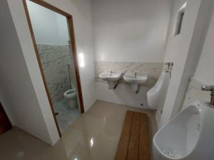 een badkamer met 2 wastafels, een urinoir en een toilet bij CMJ Private Resort 