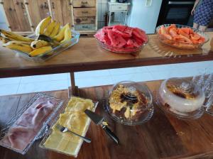 a table topped with bowls of fruit and desserts at Pousada da Maira in Foz do Iguaçu