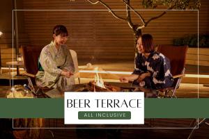 two women sitting around a table with a fire at Ichiraku tendo spa & brewery in Tendo