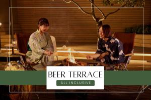 Deux femmes assises autour d'une table avec un feu dans l'établissement Ichiraku tendo spa & brewery, à Tendō