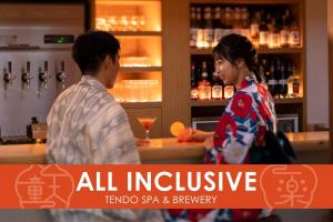天童市Ichiraku tendo spa & brewery的一男一女站在酒吧里