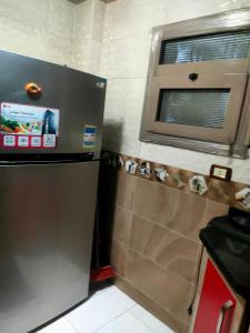 eine Küche mit einem Kühlschrank aus Edelstahl und einem Fenster in der Unterkunft شقه غرفتين نوم in Kairo