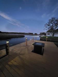 un muelle de madera con un banco en el agua en PEACE WATER INN, en Gautier