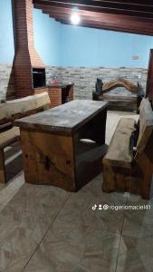 um quarto com uma mesa de madeira e um banco em Casa de campo Maciel em Joanópolis