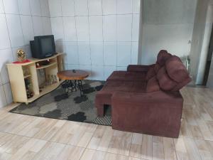 uma sala de estar com um sofá e uma mesa em Casa de campo Maciel em Joanópolis
