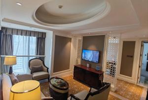 a living room with a couch and a tv at Estandon Hotel Guangzhou in Guangzhou