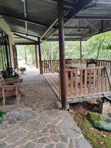 a wooden deck with a table and benches on it at Natural paradise in Turrialba +16 photos