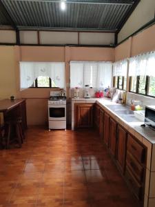 a kitchen with wooden cabinets and a stove top oven at Natural paradise in Turrialba