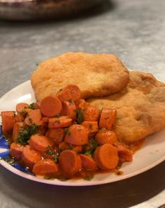 un plato de comida con zanahorias y un trozo de pan en Villas del Mar Hostal, en Cañas
