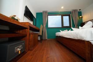 a bedroom with a bed and a flat screen tv at NT Elysian hotel in Hanoi