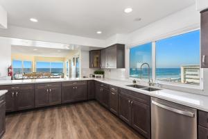 a large kitchen with a view of the ocean at Oceanfront Family Getaway - BBQ - Oceanfront Seating in Oceanside +16 photos