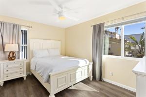 a bedroom with a white bed and a window at Oceanfront Family Getaway - BBQ - Oceanfront Seating in Oceanside