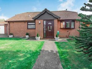 a brick house with a brown door in a yard at 2 bed in Mablethorpe 87801 in Mablethorpe