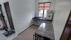 an empty kitchen with a counter and a window at Cinta Homestay Parit Raja UTHM in Parit Raja