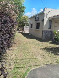 a yard next to a house with a building at Piriápolis a 4 cuadras de playa,"Las Hortensias" in Piriápolis