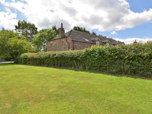 an old brick building with a hedge in front of a yard at 3 Bed in Ironbridge HWLOC in Buildwas