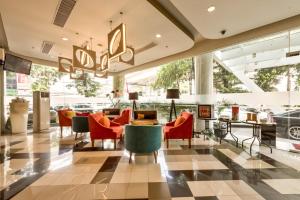 a lobby of a hotel with chairs and tables at Maxone Premier Melawai in Jakarta +27 photos