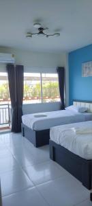 een kamer met 3 bedden en een groot raam bij TPR51 Room Service in Ban Hua Khao Sammuk