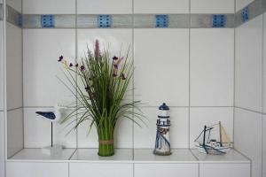 a vase with flowers on a shelf in a bathroom at DUeNENHOF-4 in Olsdorf