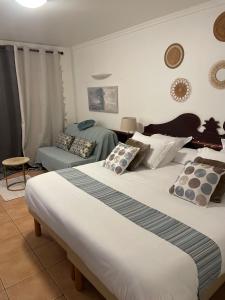 a bedroom with two beds and a couch at Studio Charme et cosy à Sainte-Luce Martinique in Sainte-Luce