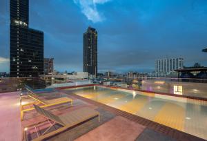 a swimming pool on top of a building with a city skyline at The Quarter Ratchathewi by UHG in Pom Prap