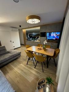 Sala de estar con mesa de comedor y TV en Narciarska6A Apartamenty en Szczyrk