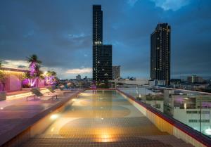 una piscina en la azotea en un edificio con vistas al perfil urbano en The Quarter Ratchathewi by UHG, en Pom Prap