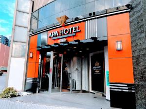 un edificio con un letrero naranja en la parte delantera. en APA Hotel Chiba Yachiyo Midorigaoka, en Yachiyo