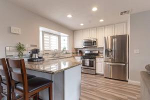 a kitchen with stainless steel appliances and wooden floors at Ohana’s Home in Chula Vista