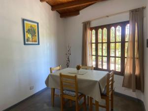 a dining room with a table and chairs and a window at DYCS DEPARTAMENTOS in San Rafael