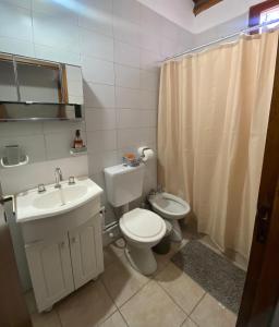 a bathroom with a white toilet and a sink at DYCS DEPARTAMENTOS in San Rafael