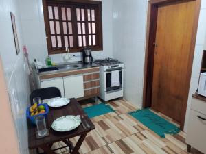a small kitchen with a table and a stove at Cantinho da Saudade in Campos do Jordão