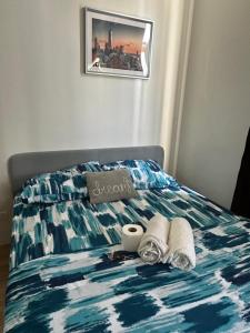 Una cama con dos toallas y una taza. en Neat Unit in Holland Park Southwoods, en Biñan