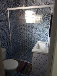 a bathroom with a shower with a toilet and a sink at Cantinho da Saudade in Campos do Jordão +5 photos