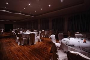 un salón de banquetes con mesas y sillas blancas en Siris Hotel, en Serres