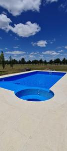 een groot blauw zwembad in het midden van een veld bij Casa de campo El Olam in San Miguel del Monte