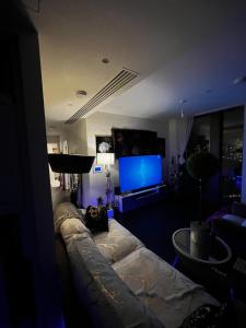 a living room with a couch and a flat screen tv at Luxurious Versace Apartment in London