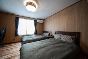 1 dormitorio con 2 camas y ventana en Capricious INN kita27jyou en Sapporo