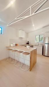 a kitchen with a counter and stools in a room at Private Guest House in Wongawallan